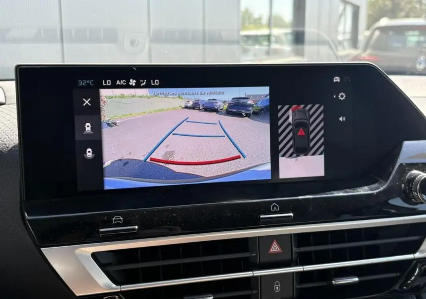 Coffre ouvert vu de l'arrière d'une Citroën C4 Hybrid 145 ch blanc Okenite, espace de chargement vide et propre.