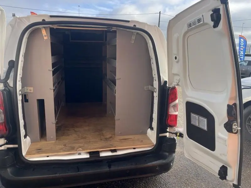 Vue arrière ouverte du Citroën Berlingo Fourgon blanc Banquise montrant l'espace de chargement avec étagères intégrées.