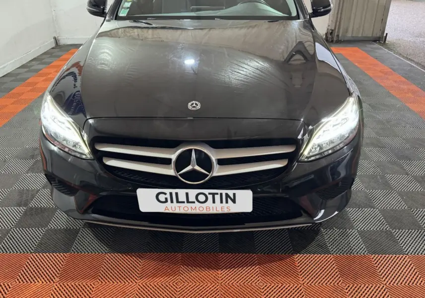 Vue frontale rapprochée d'une Mercedes Classe C Break C 200 d Business Line noire avec phares LED allumés.