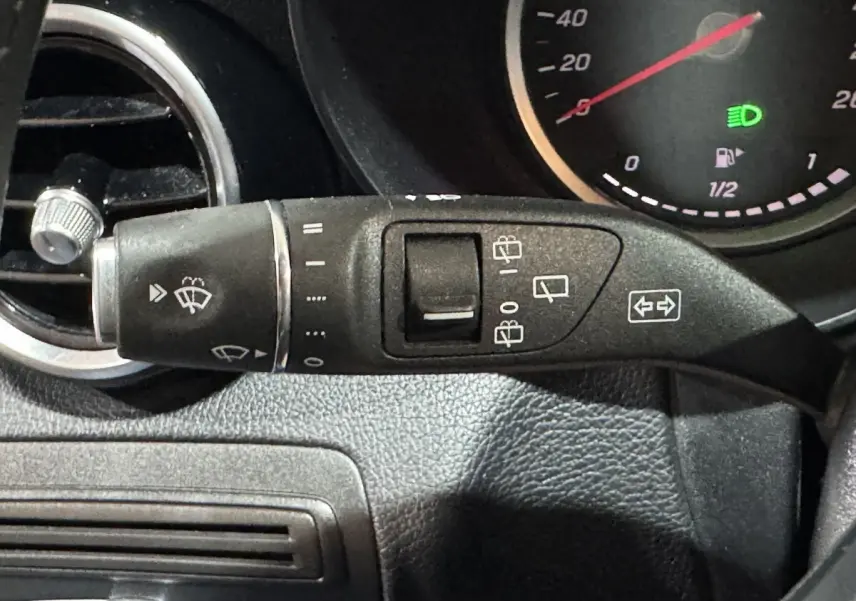 Gros plan sur la commande d’essuie-glace à gauche du volant dans le tableau de bord noir du Mercedes Classe C Break C 200 d Business Line.
