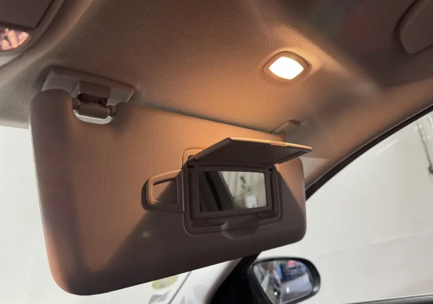 Miroir de courtoisie ouvert sur pare-soleil côté conducteur dans l'habitacle d'une Mercedes Classe C Break noire.