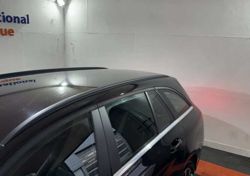 Vue 3/4 arrière côté droit d'un Mercedes Classe C Break C 200 d Business Line noir stationné en intérieur.