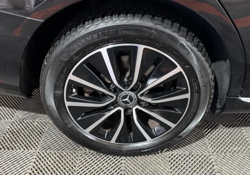 Gros plan sur la roue avant gauche noire d’un Mercedes Classe C Break C 200 d Business Line avec jante alliage bicolore.