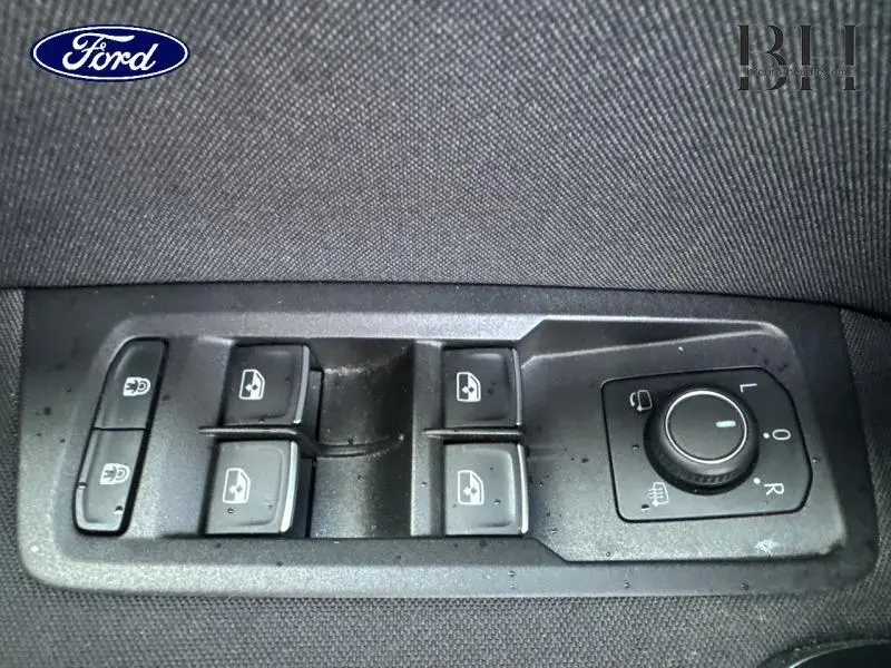 Panneau de commandes des vitres et rétroviseurs côté conducteur d'un Volkswagen Touran 1.5 TSI argent métallisé, vue intérieure rapprochée.