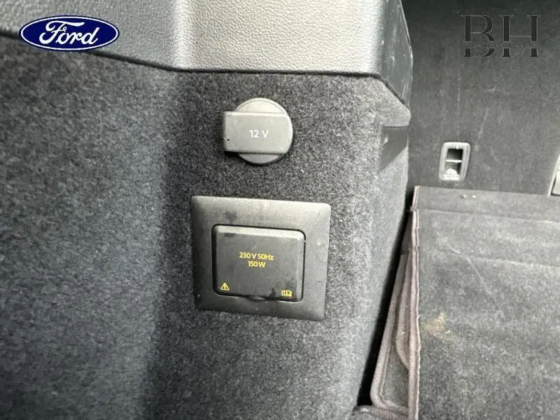 Prise 12V et prise 230V 150W dans le coffre du Volkswagen Touran 1.5 TSI Carat 2021 couleur Reflet d'Argent.