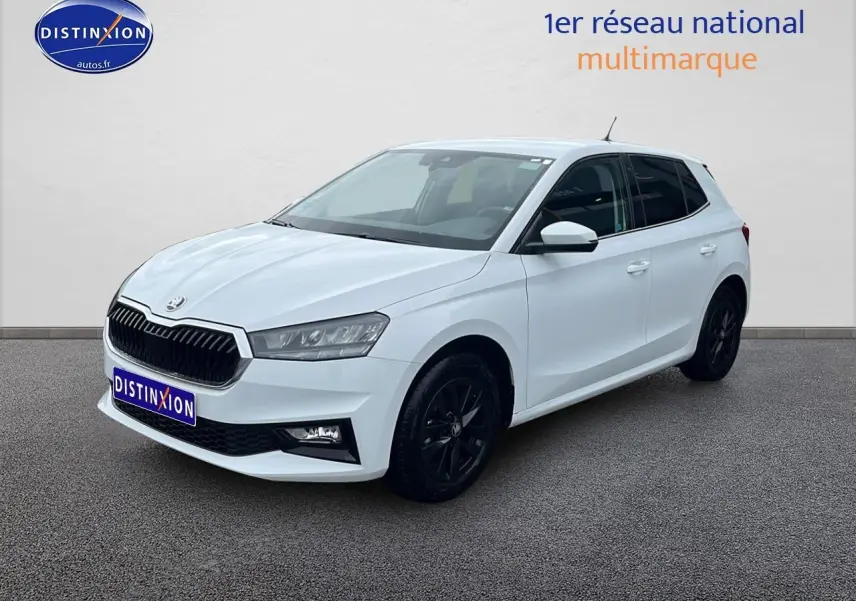 SKODA FABIA blanche vue 3/4 avant droit avec jantes noires et calandre chromée sur fond neutre.