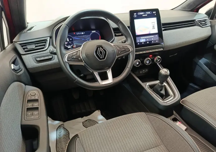 Vue intérieure avant de la Renault Clio Techno TCe 90 2024, volant cuir, écran tactile vertical et boîte manuelle.