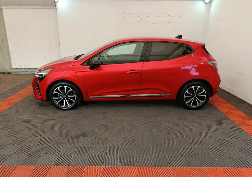 Profil côté gauche de la Renault Clio Techno TCe 90 rouge 2024, avec jantes alliage et vitres teintées.