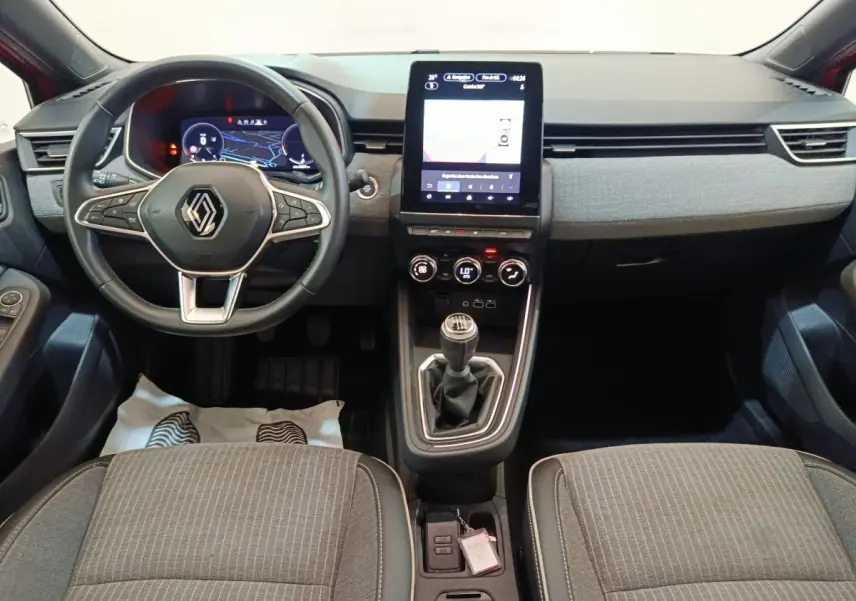 Vue intérieure avant de la Renault Clio Techno TCe 90 2024, volant multifonctions, écran tactile vertical et levier de vitesse manuel.