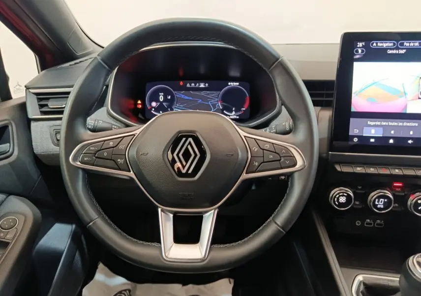 Vue rapprochée du volant cuir de la Renault Clio Techno TCe 90 2024 avec tableau de bord numérique et écran tactile central.
