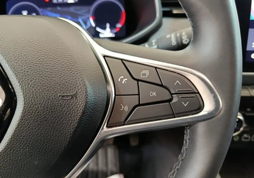 Gros plan sur le côté droit du volant cuir de la Renault Clio Techno TCe 90 2024 avec commandes multifonctions.