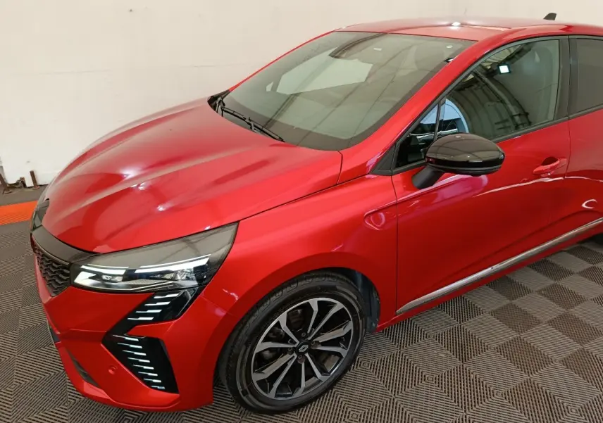 Vue 3/4 avant droite d'une Renault Clio Techno TCe 90 rouge avec phares LED et jantes alliage noires.