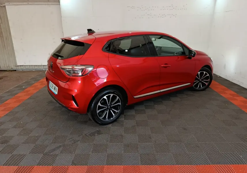 Renault Clio Techno TCe 90 rouge vue 3/4 arrière droit, jantes alliage noires et vitres teintées.
