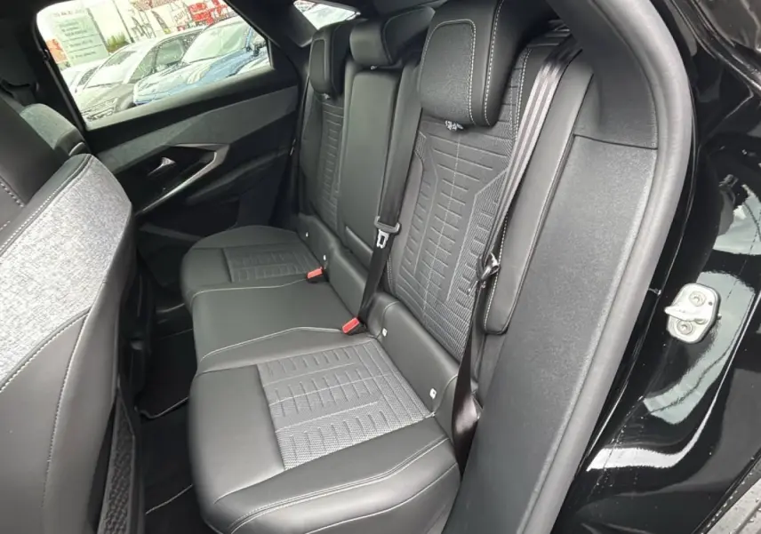 Vue côté droit de la banquette arrière en sellerie Alcantara et tissu gris, dans un Peugeot 3008 noir perla 2026.