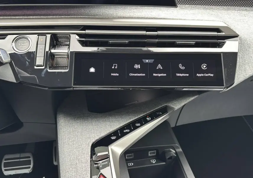 Vue rapprochée de la console centrale du Peugeot 3008 2026, avec écran tactile panoramique et commandes tactiles sur finition tissu gris.