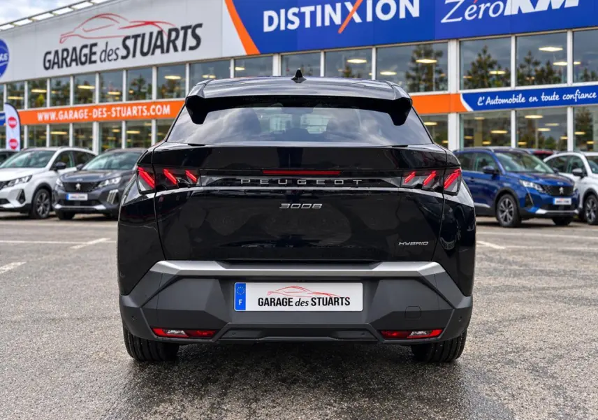 Vue arrière d’un Peugeot 3008 noir perla hybride, avec feux arrière LED en forme de griffes et hayon fermé.