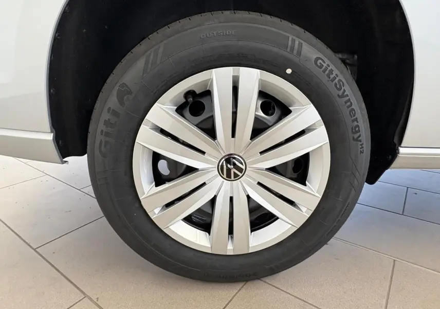 Gros plan sur la roue avant gauche gris argent du Volkswagen Caddy 2025 avec jante à enjoliveur moderne.