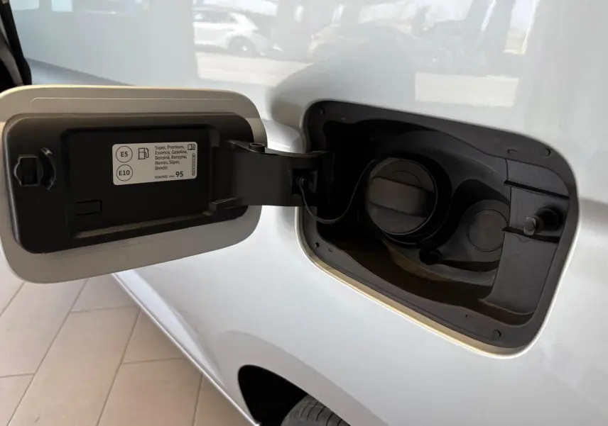 Bouchon de réservoir essence ouvert sur le côté gauche d'un Volkswagen Caddy gris argent 2025, version Business.