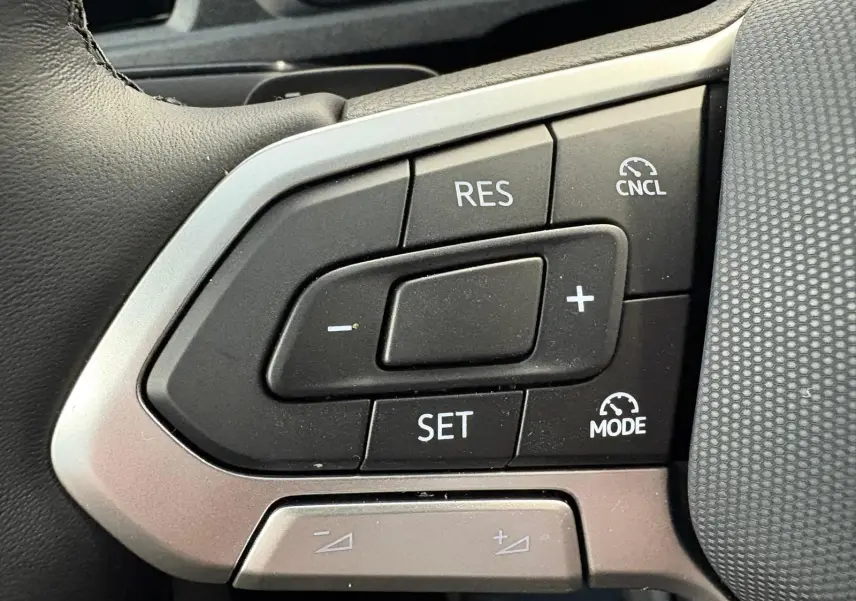 Gros plan sur les commandes de régulateur de vitesse au volant d'un Volkswagen Caddy gris argent 2025.