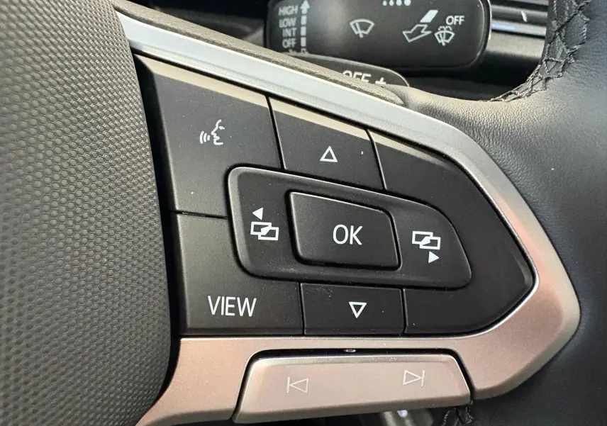 Gros plan sur les commandes multifonctions du volant gris argenté du Volkswagen Caddy 2025, version Business.