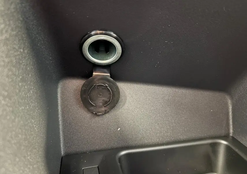 Prise 12V ouverte dans le compartiment de rangement intérieur du Volkswagen Caddy gris argent 2025.