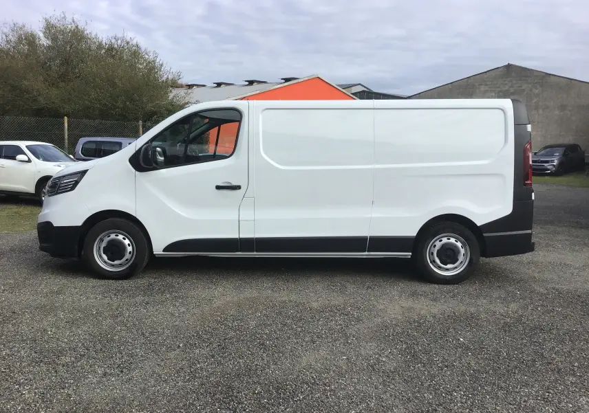Profil côté gauche d'un fourgon Renault Trafic blanc, version L2H1 3T, avec jantes acier et pare-chocs noirs.