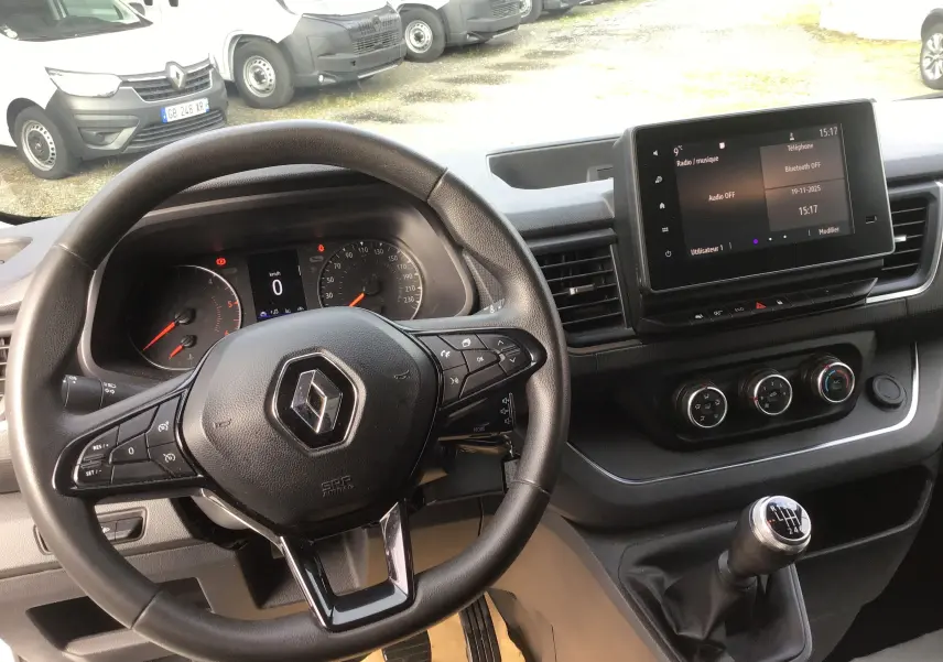 Vue intérieure du tableau de bord du Renault Trafic Fourgon blanc 2022, volant multifonction et écran tactile 8 pouces visible.