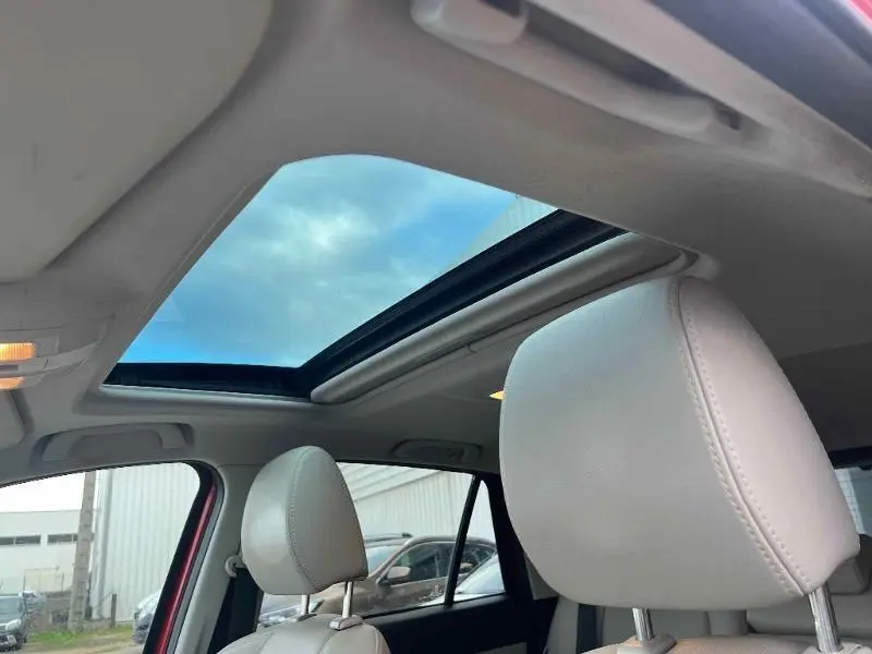 Vue intérieure du toit ouvrant électrique et des appuie-têtes en cuir clair du Mazda CX-5 Soul Red Métallisé 2013.