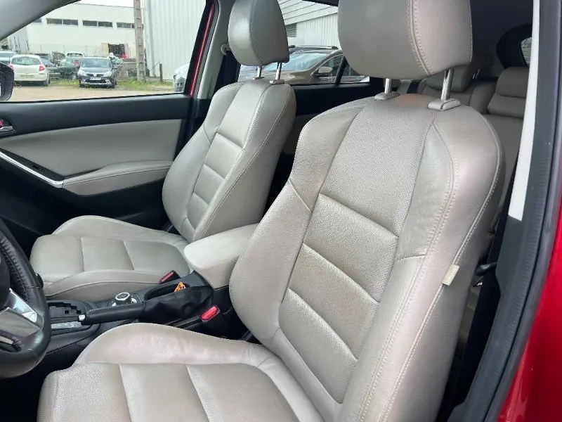 Vue intérieure côté avant droit montrant les sièges cuir beige du Mazda CX-5 Soul Red Métallisé 2013.