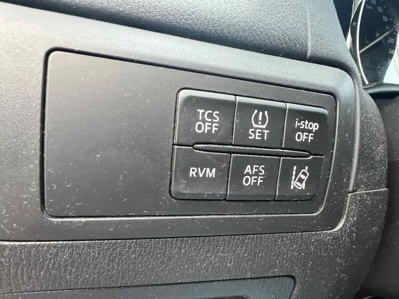 Gros plan sur les boutons de commande noirs du tableau de bord côté gauche du Mazda CX-5 Soul Red Métallisé 2013.