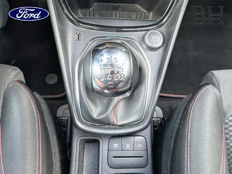 Vue plongeante sur le levier de vitesses manuel chromé et la console centrale noire du Ford Puma 2020 intérieur sport.