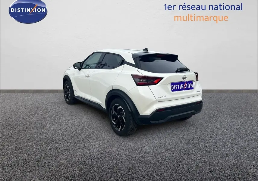 Vue 3/4 arrière droite du Nissan Juke blanc nacré métallisé 2024 avec jantes noires et vitres teintées.