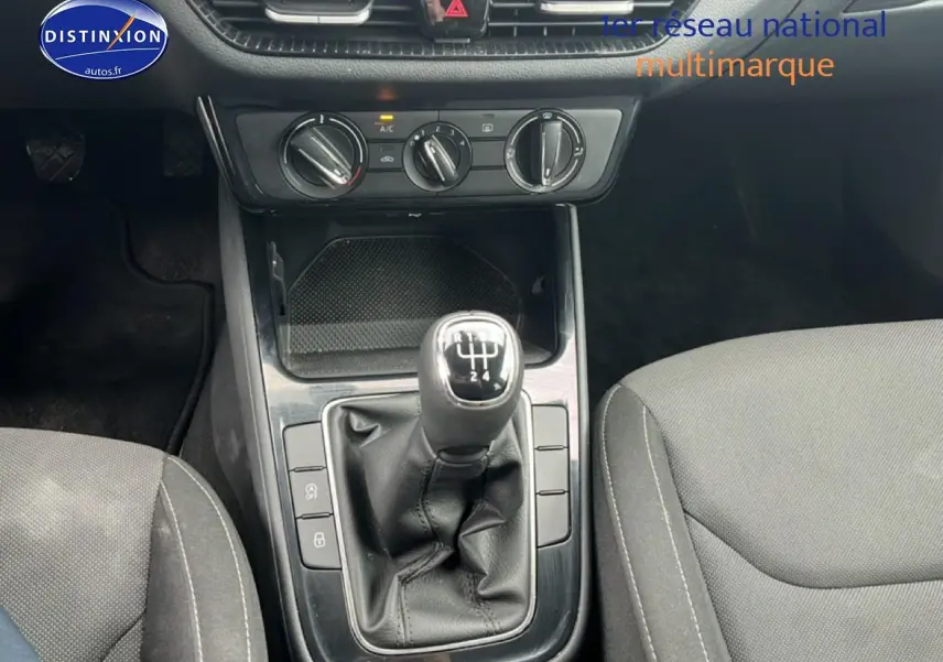 Gros plan sur la console centrale de la Skoda Fabia blanche 2025 avec levier de vitesse manuel et commandes de climatisation.