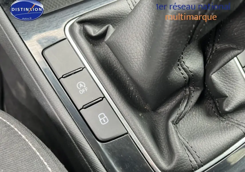 Gros plan sur la console centrale noire avec levier de vitesses cuir et boutons de commande sur Skoda Fabia blanche.