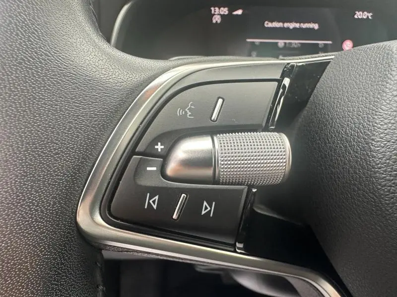 Gros plan sur les commandes multifonctions en noir et chrome du volant d'une Skoda Scala noir Magic nacré, version 2025.