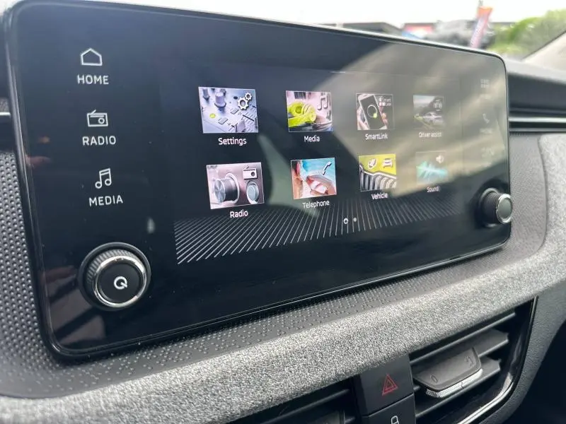 Écran tactile central de la Skoda Scala 2025 affichant le menu multimédia avec commandes physiques sur le côté gauche.