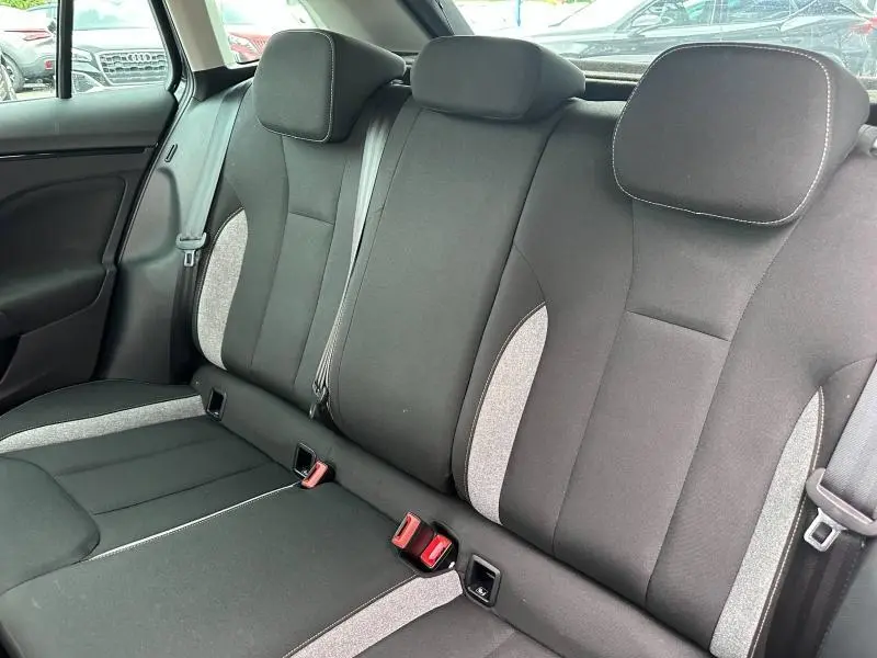 Vue intérieure de la banquette arrière noire et grise du Skoda Scala 2025 avec ceintures et appuie-têtes visibles.