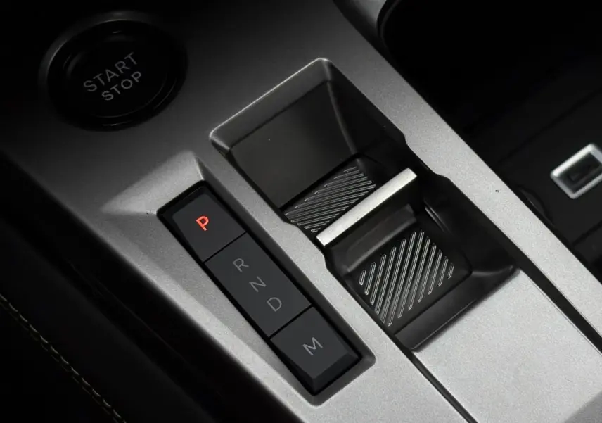 Gros plan sur la commande de boîte automatique et bouton start/stop du Peugeot 308 SW gris Sélénium, intérieur moderne.