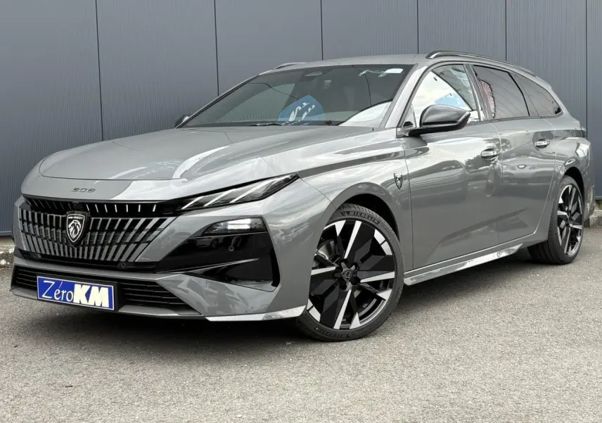 Peugeot 308 SW gris Sélénium vue 3/4 avant, avec jantes alliage bi-tons et calandre noire distinctive.