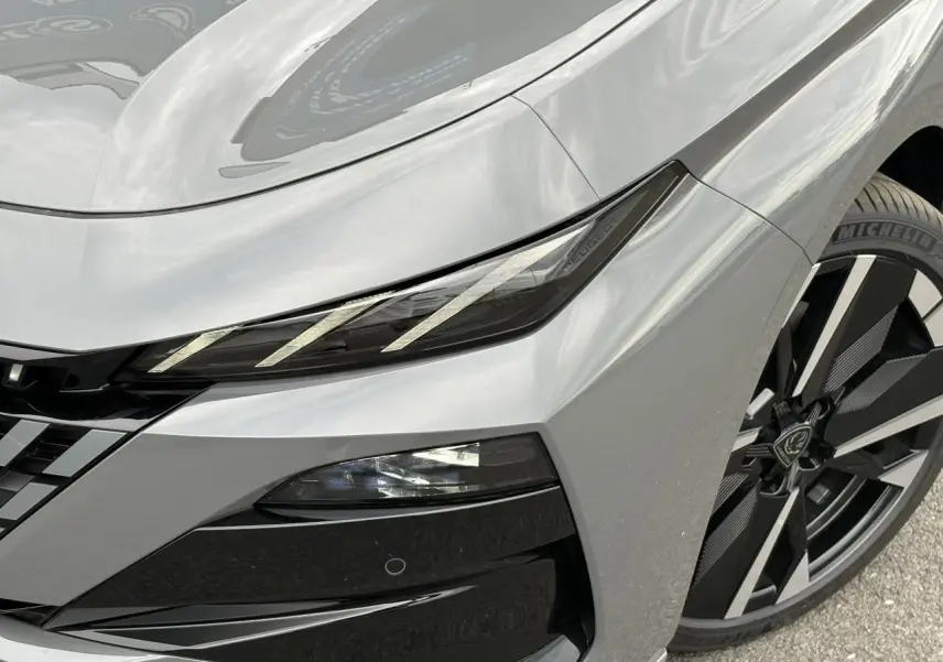 Gros plan sur l'avant droit gris Sélénium du Peugeot 308 SW avec phares LED et jante alliage bi-tons.