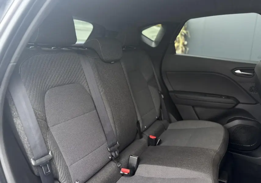 Vue intérieure sur les sièges arrière gris foncé du Renault Captur TCE 100 Techno avec ceintures et appuie-têtes visibles.