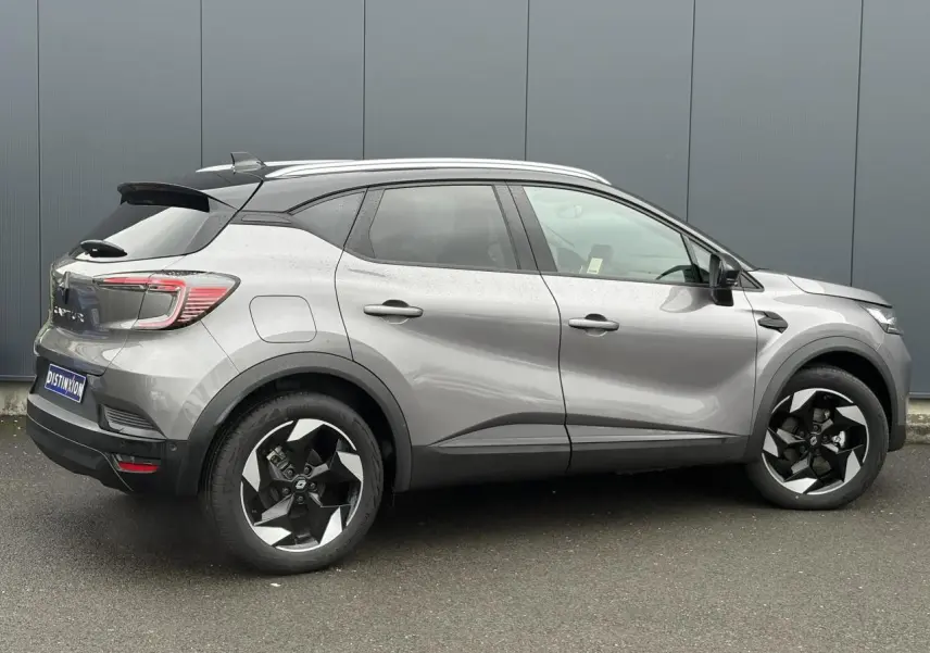 Vue latérale droite d'un Renault Captur 2025 gris Cassiopée avec toit noir et jantes alu 18 pouces diamantées noires.