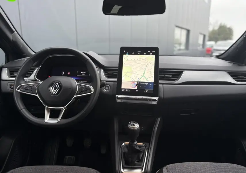 Vue intérieure frontale du tableau de bord du Renault Captur TCE 100 Techno 2025 avec écran tactile vertical et boîte manuelle.