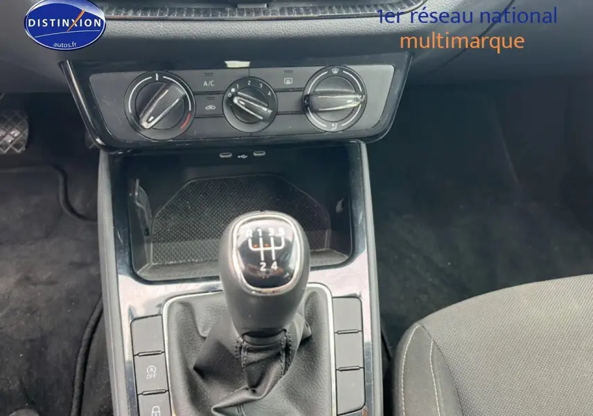 Gros plan sur la console centrale noire d’une Skoda Fabia 2025 avec levier de vitesses manuel et commandes de climatisation.