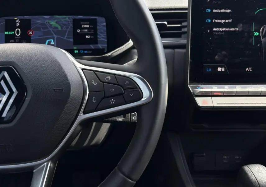 Vue rapprochée du volant cuir multifonctions et tableau de bord numérique du Renault Captur E-Tech 2025, intérieur noir.