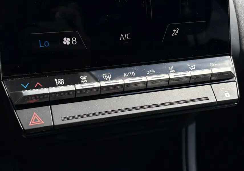 Vue rapprochée des commandes de climatisation et sécurité du tableau de bord du Renault Captur E-Tech Full Hybrid 2025.