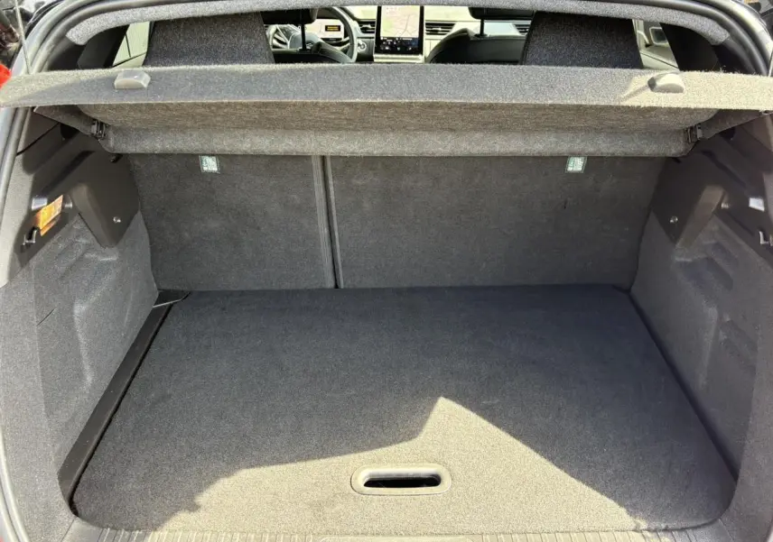 Vue du coffre ouvert d'un Renault Captur E-Tech rouge, montrant l'espace de chargement et l'intérieur arrière noir.