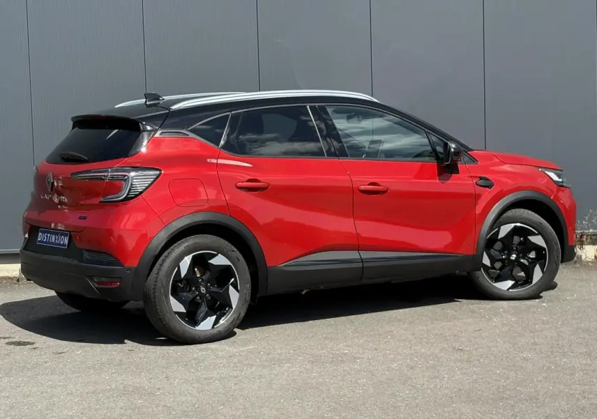 Vue latérale droite du Renault Captur E-Tech Full Hybrid 145 Techno rouge Désir avec toit noir étoilé et jantes 18 pouces.