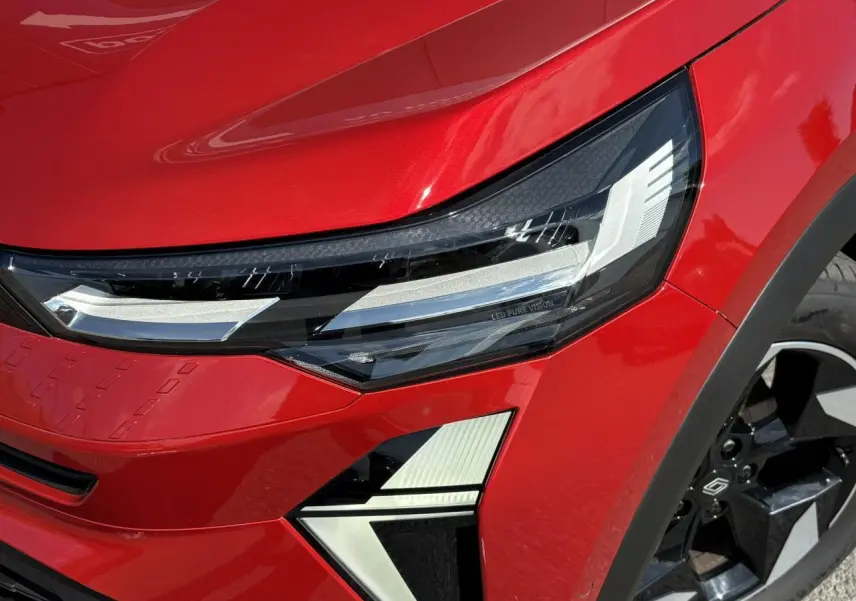 Gros plan sur le phare avant droit LED Pure Vision et la roue noire à jante aluminium du Renault Captur Rouge Désir.
