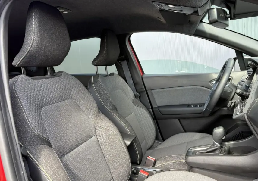 Vue intérieure côté gauche du Renault Captur E-Tech rouge, montrant les sièges avant en tissu gris et la console centrale.